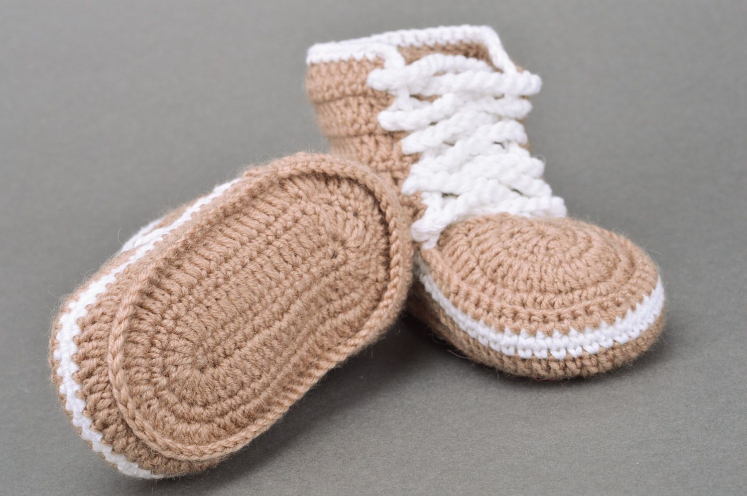 Originelle hellbraune gehäkelte Babyschuhe mit Schuhbändern in Form der Turnschuhen foto 5