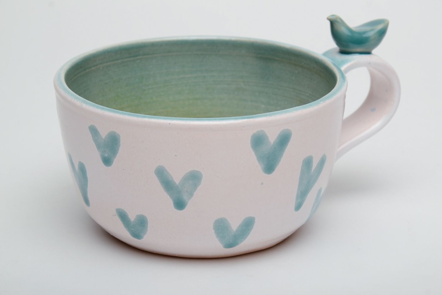 Porcelain white coffee cup with green glaze inside with handle and heart shape pattern photo 2