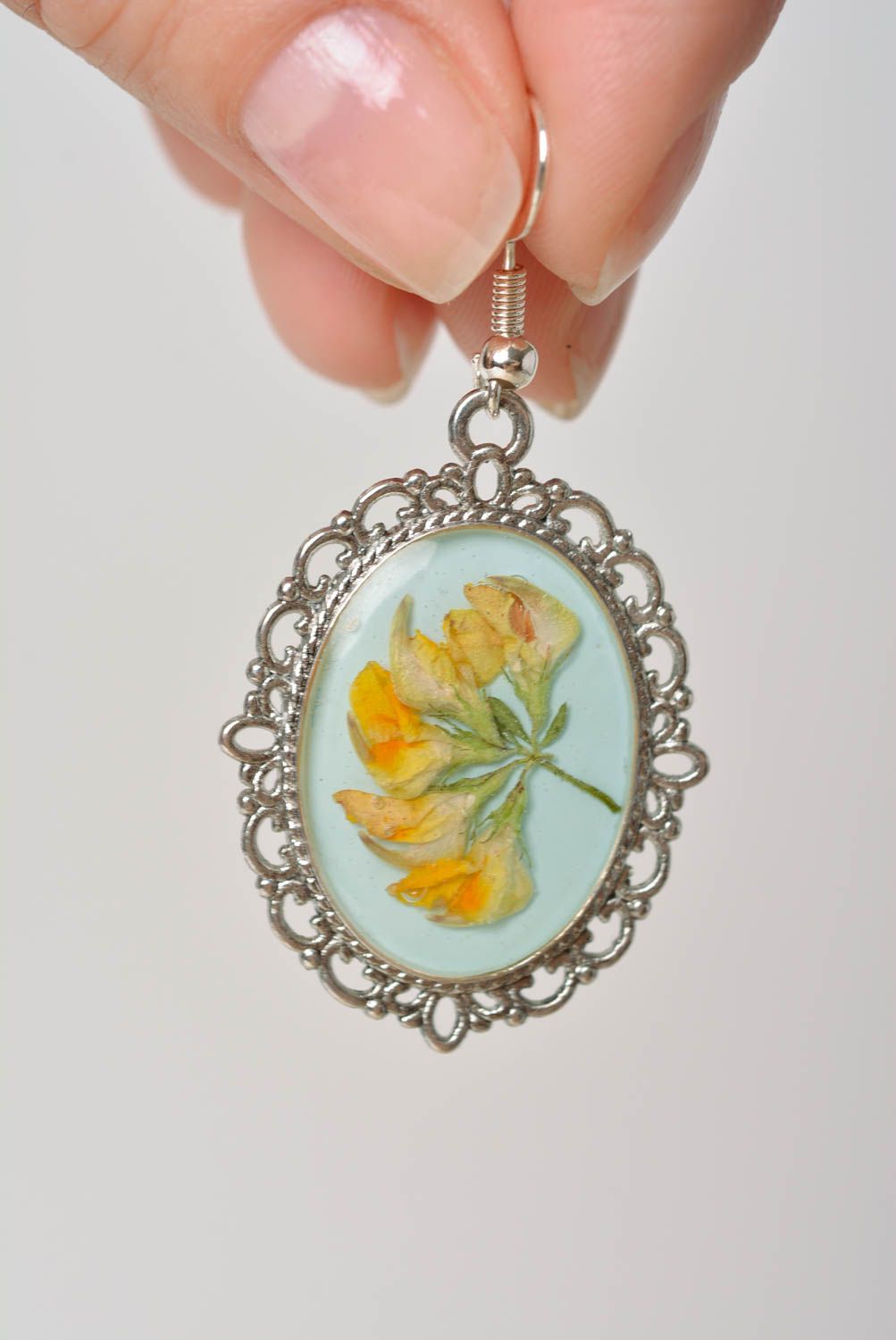 Handmade oval dangle earrings with metal basis and dried flowers in epoxy resin photo 2