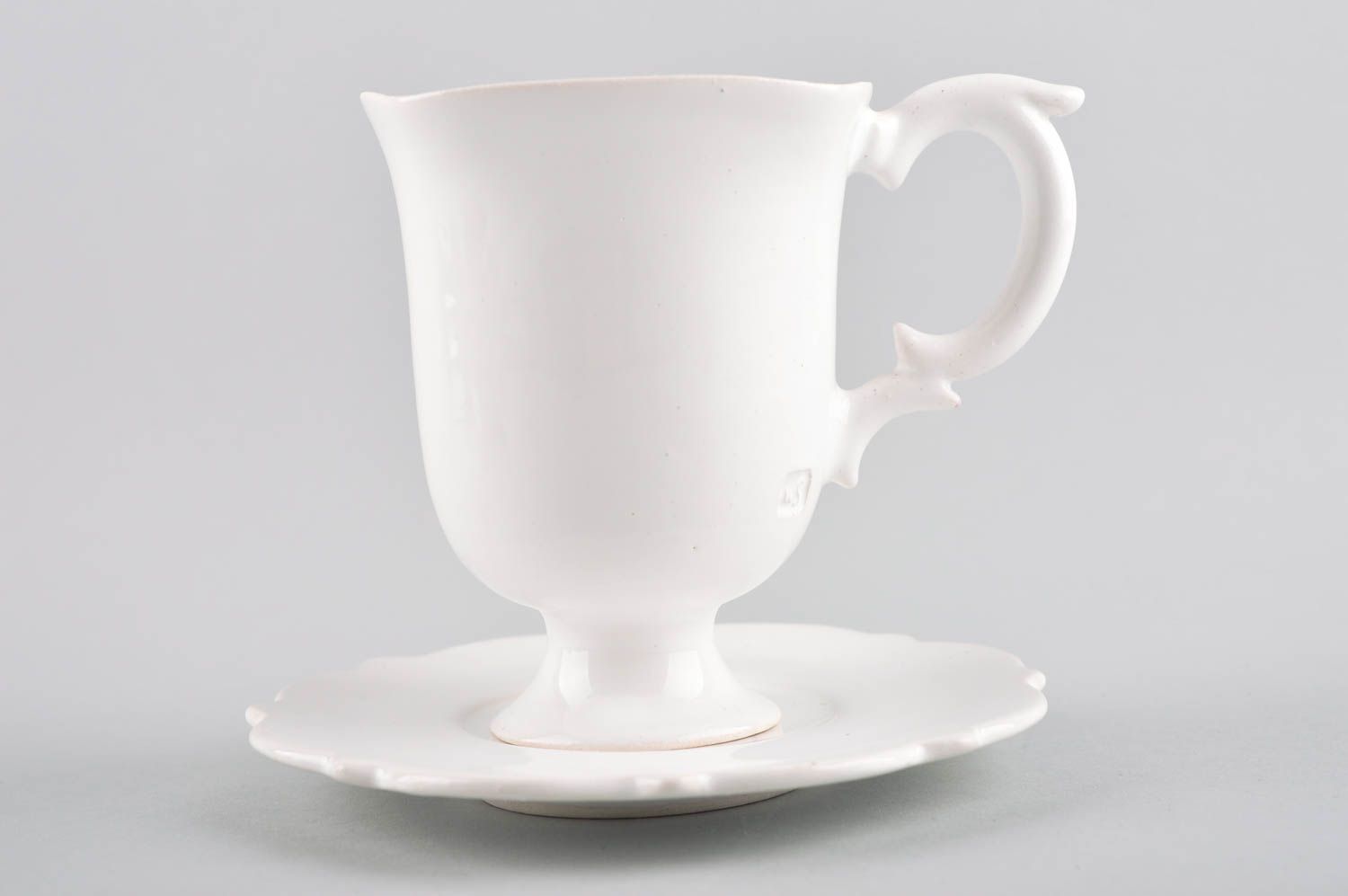 White plain porcelain teacup on the stand in elegant design with handle and saucer photo 2