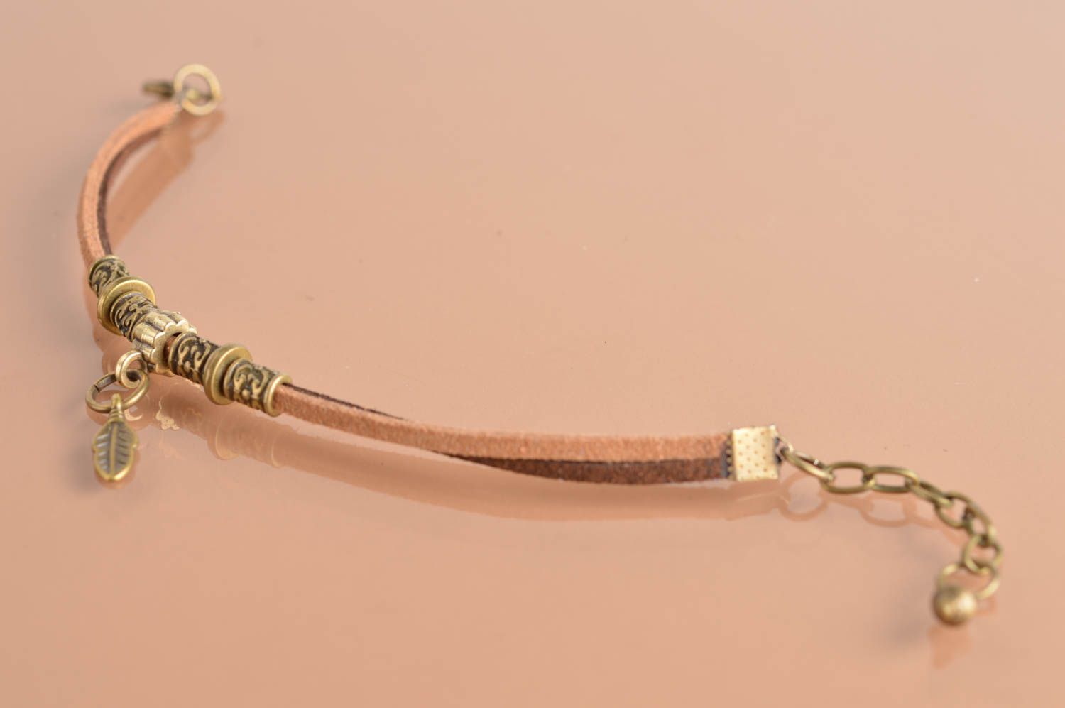 Handmade designer thin bracelet made of chamois leather lace with goldish charms photo 2