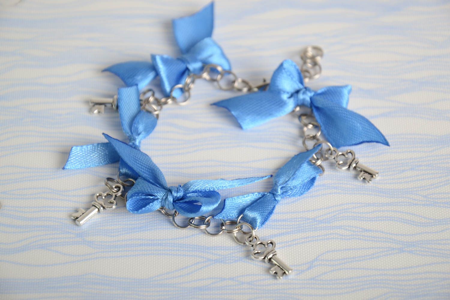Bracelet avec pendeloques et noeuds en satin bleu ciel élégant fait main femme photo 1