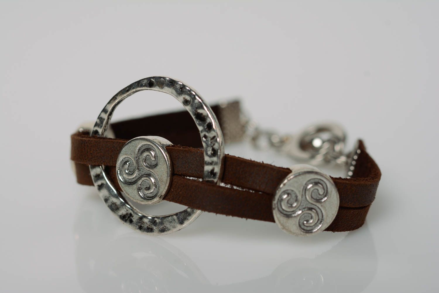 Interessantes handmade braunes Armband aus Leder mit Metalleinsätzen foto 1