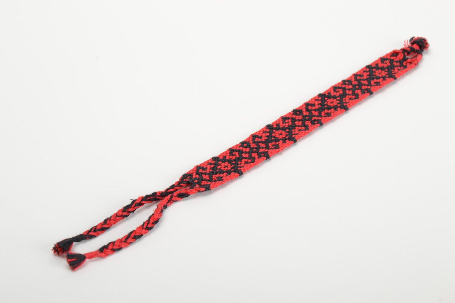 Handmade friendship wrist bracelet woven of threads with red and black ornament photo 2