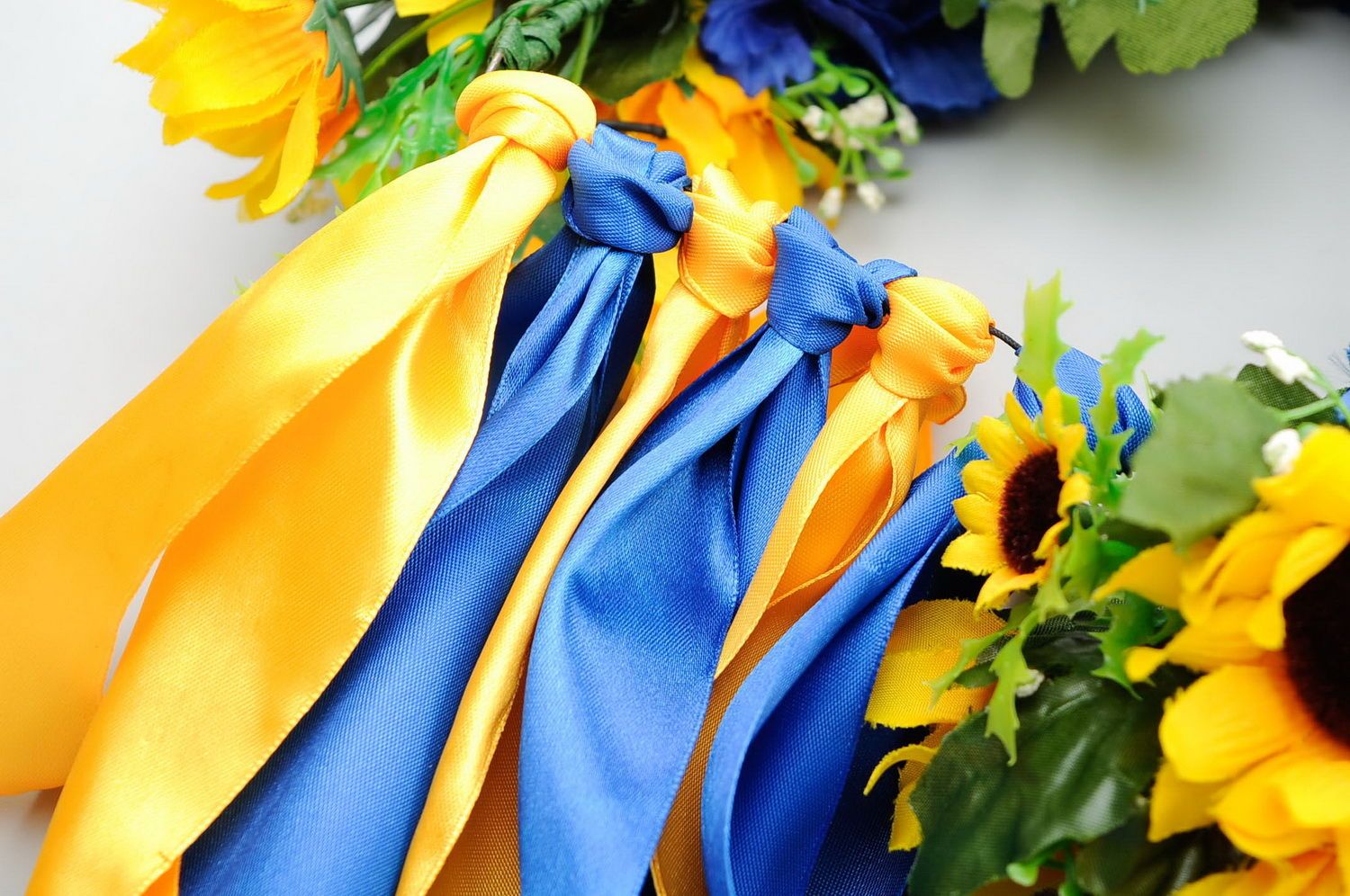 Corona con flores artificiales y cintas de color amarillo y azul foto 5