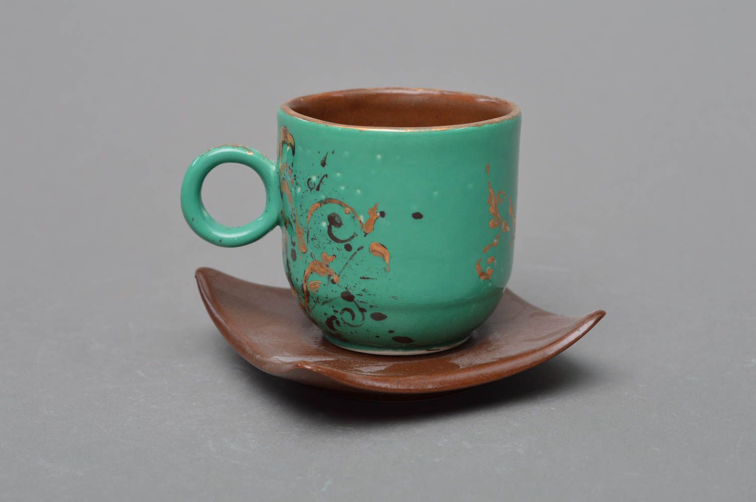 Türkise mit Glasur bemalte handgemachte Tasse aus Porzellan mit Unterteller foto 1