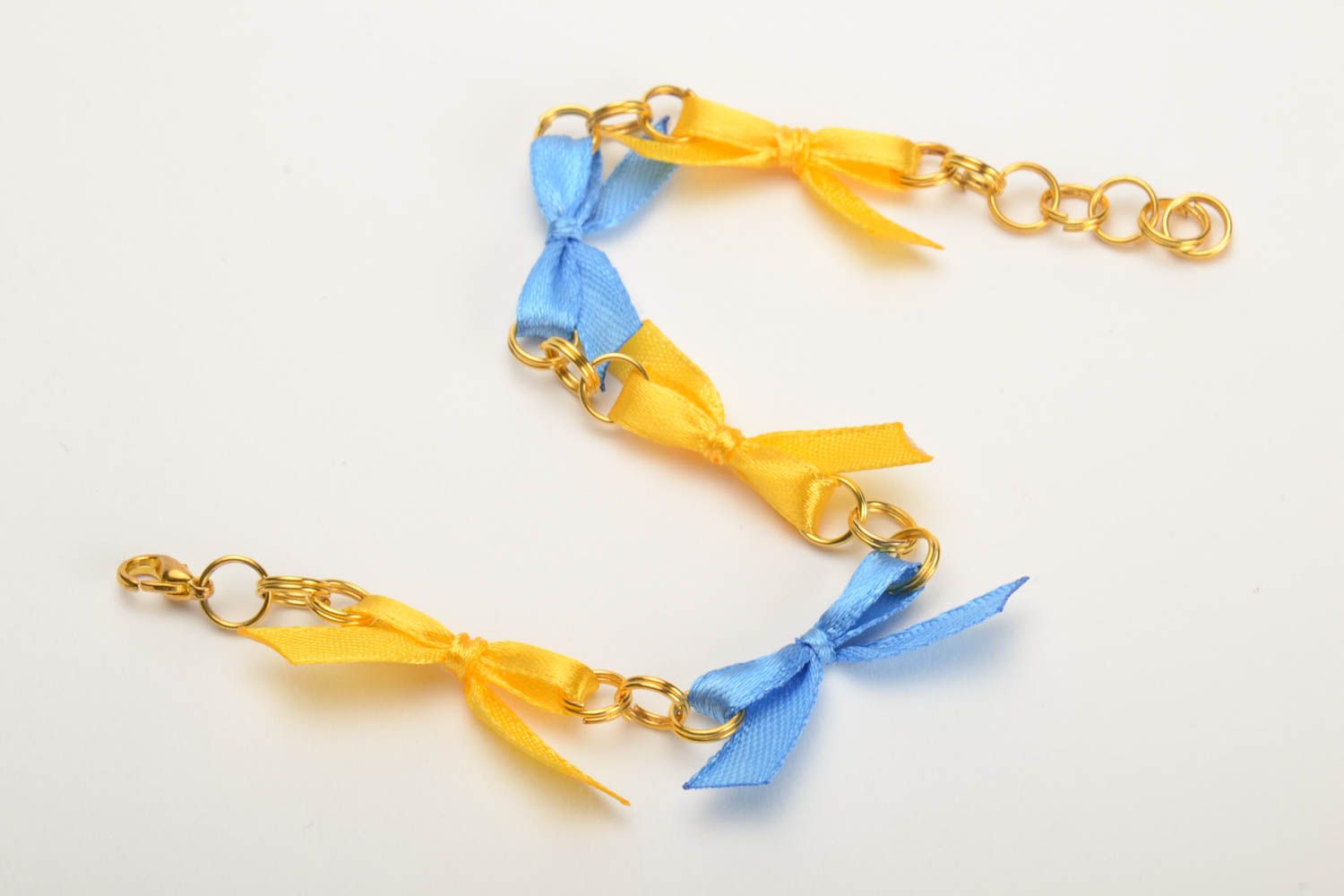Pulsera artesanal original con lacitos de cintas de raso en cadena amarilla azul foto 2