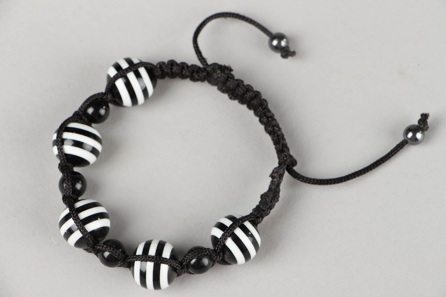 Черно-белый плетеный браслет с бусинами фото 3