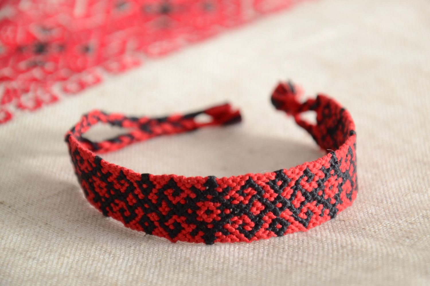 Handmade friendship wrist bracelet woven of threads with red and black ornament photo 1