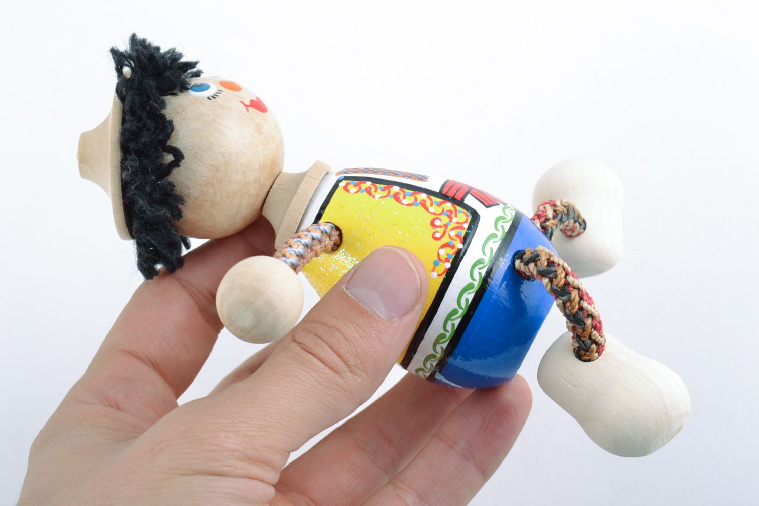 Handmade wooden eco toy in the shape of boy painted in ethnic style for kids photo 2