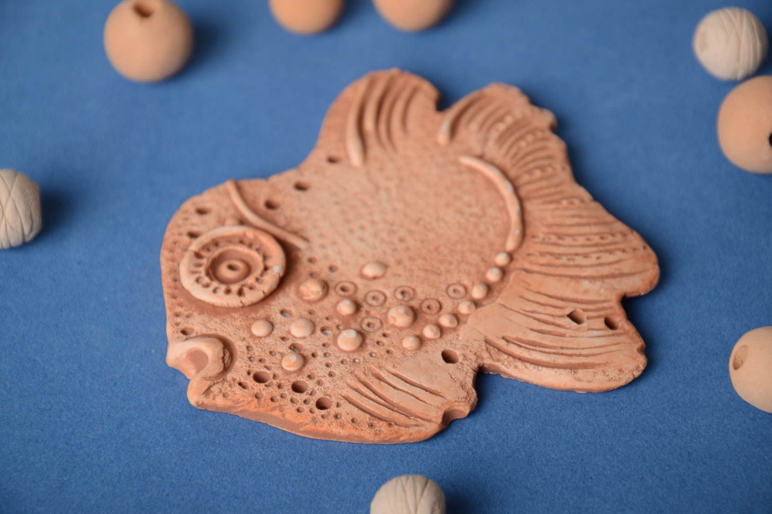 Homemade flat pendant molded of pottery clay in the shape of decorative fish photo 1