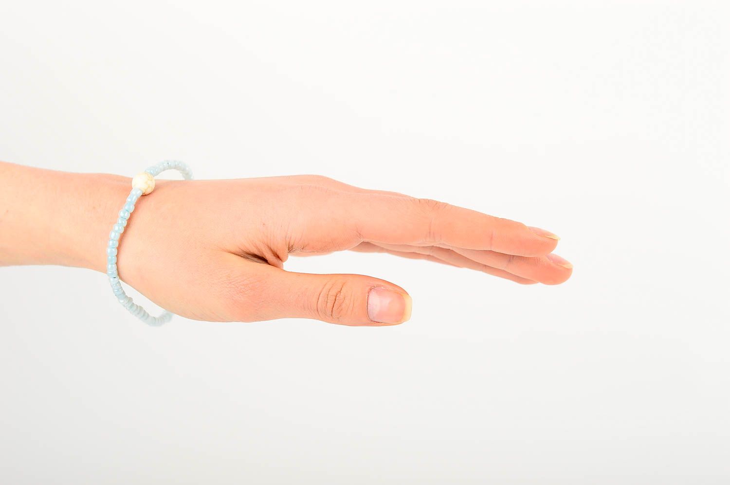 Handmade pale blue beaded stretchy wrist bracelet with beige ball shape centerpiece photo 2