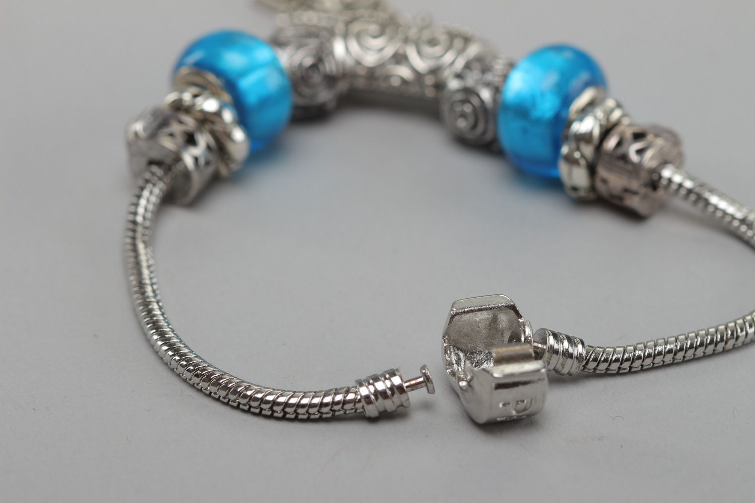 Thin handmade wrist bracelet with blue glass beads and metal charm for women photo 4