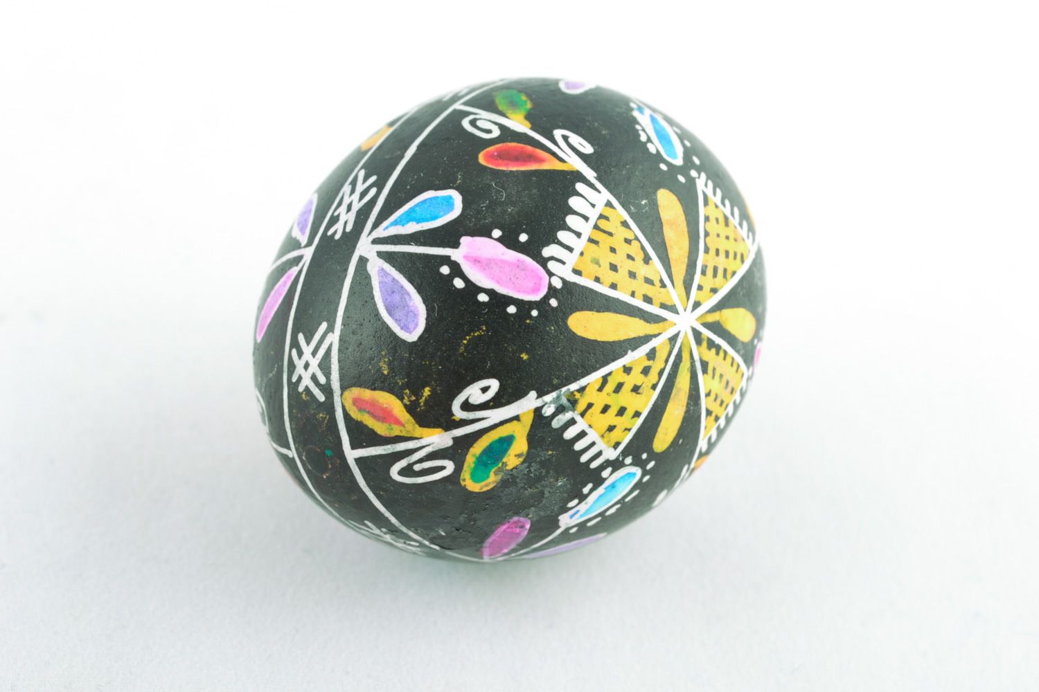Handmade Easter egg with floral ornament on black background painted with wax photo 4