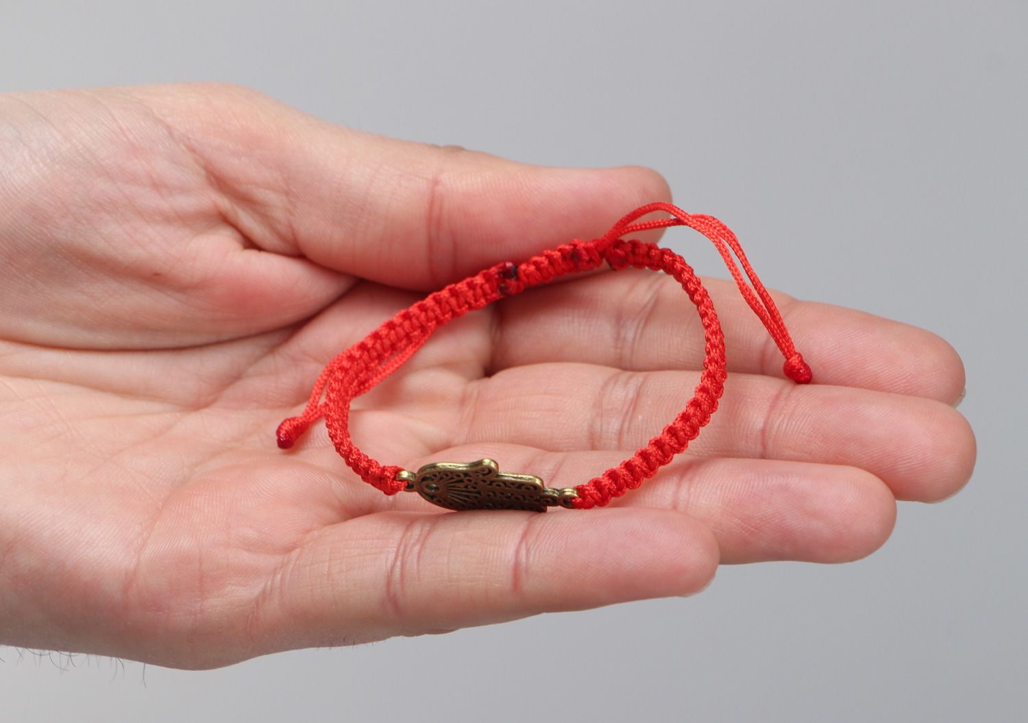 Thin handmade wrist friendship bracelet of red color with metal charm unisex photo 3