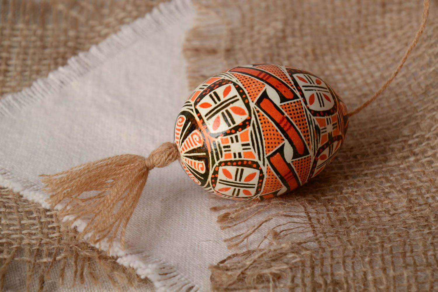 Handmade decorative Easter egg painted in brown color palette with beige tassel photo 1
