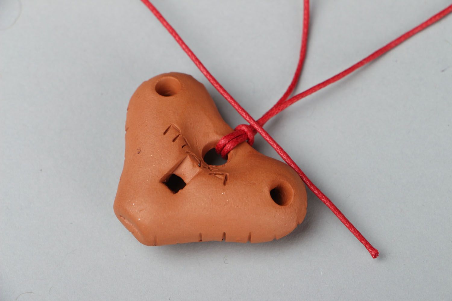 Clay penny whistle with a red cord photo 3