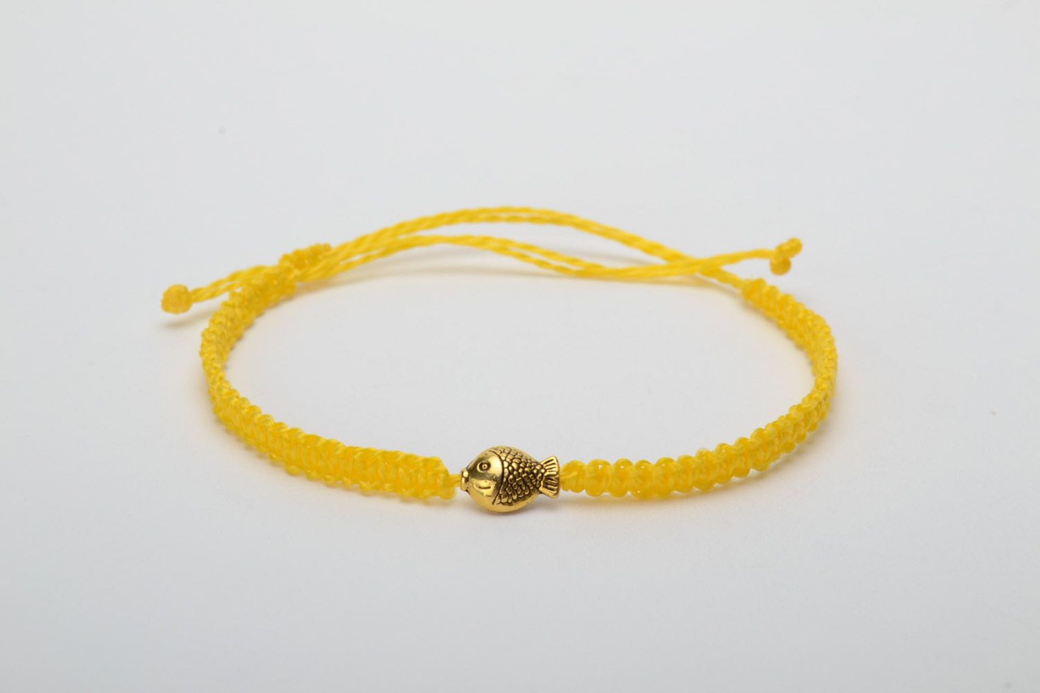 Handmade women's designer macrame woven bracelet of yellow color with metal charm in the shape of fish photo 5
