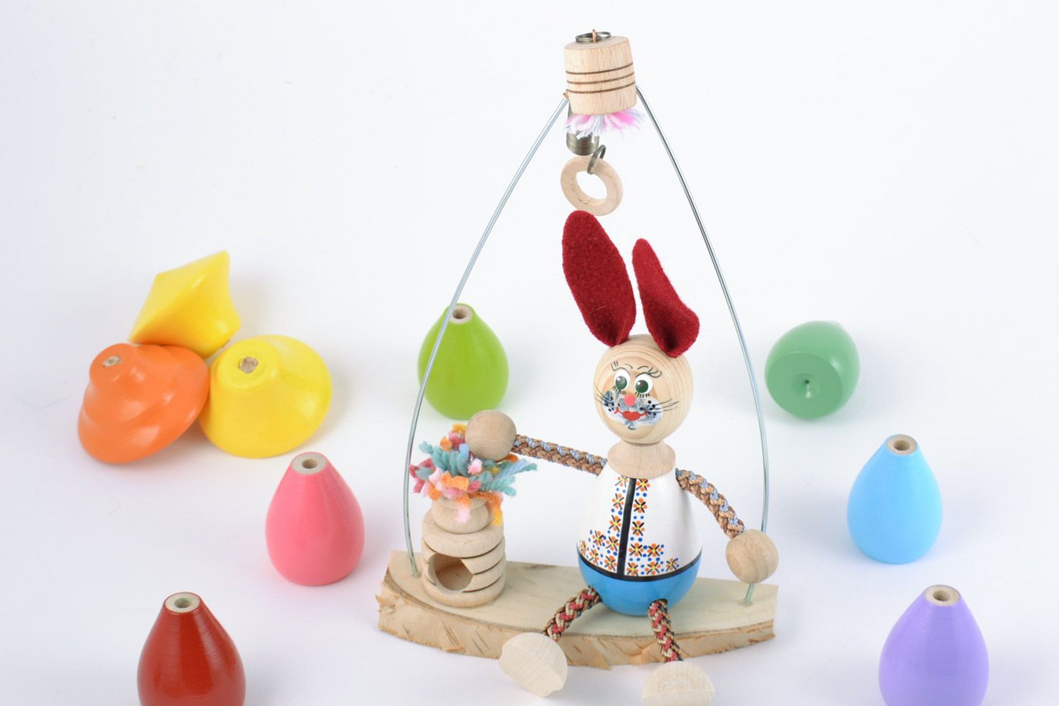 Handmade cute painted beech wood eco toy rabbit with red ears sitting on swing  photo 1