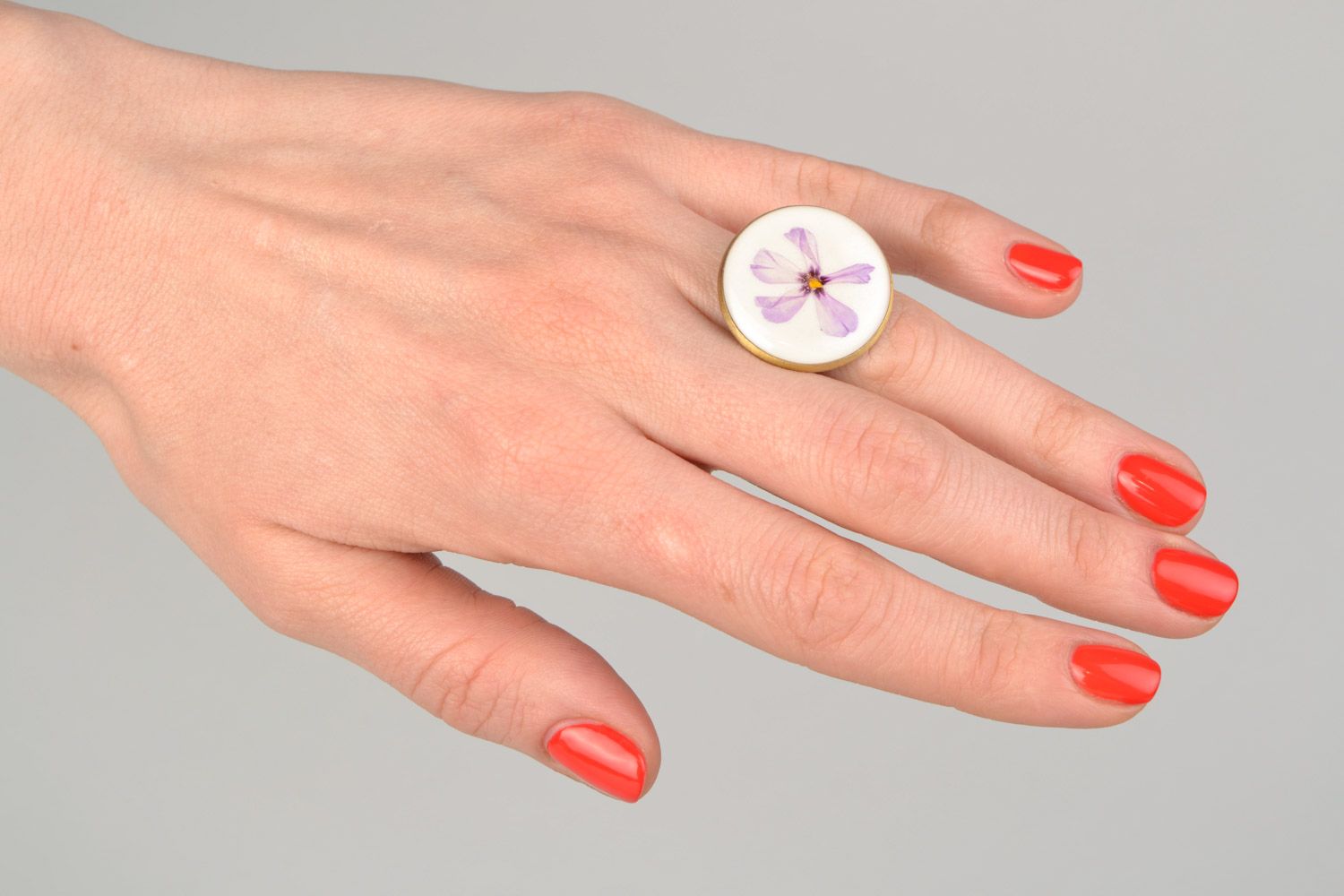 Handmade round ring with natural flowers on white background in epoxy resin photo 2