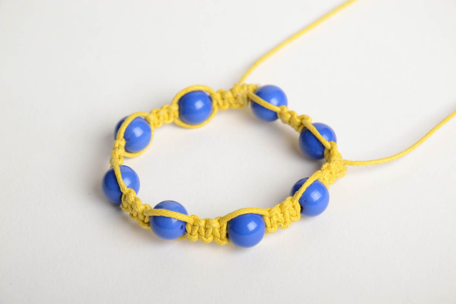 Handmade friendship bracelet woven of yellow cord and blue beads for children photo 4