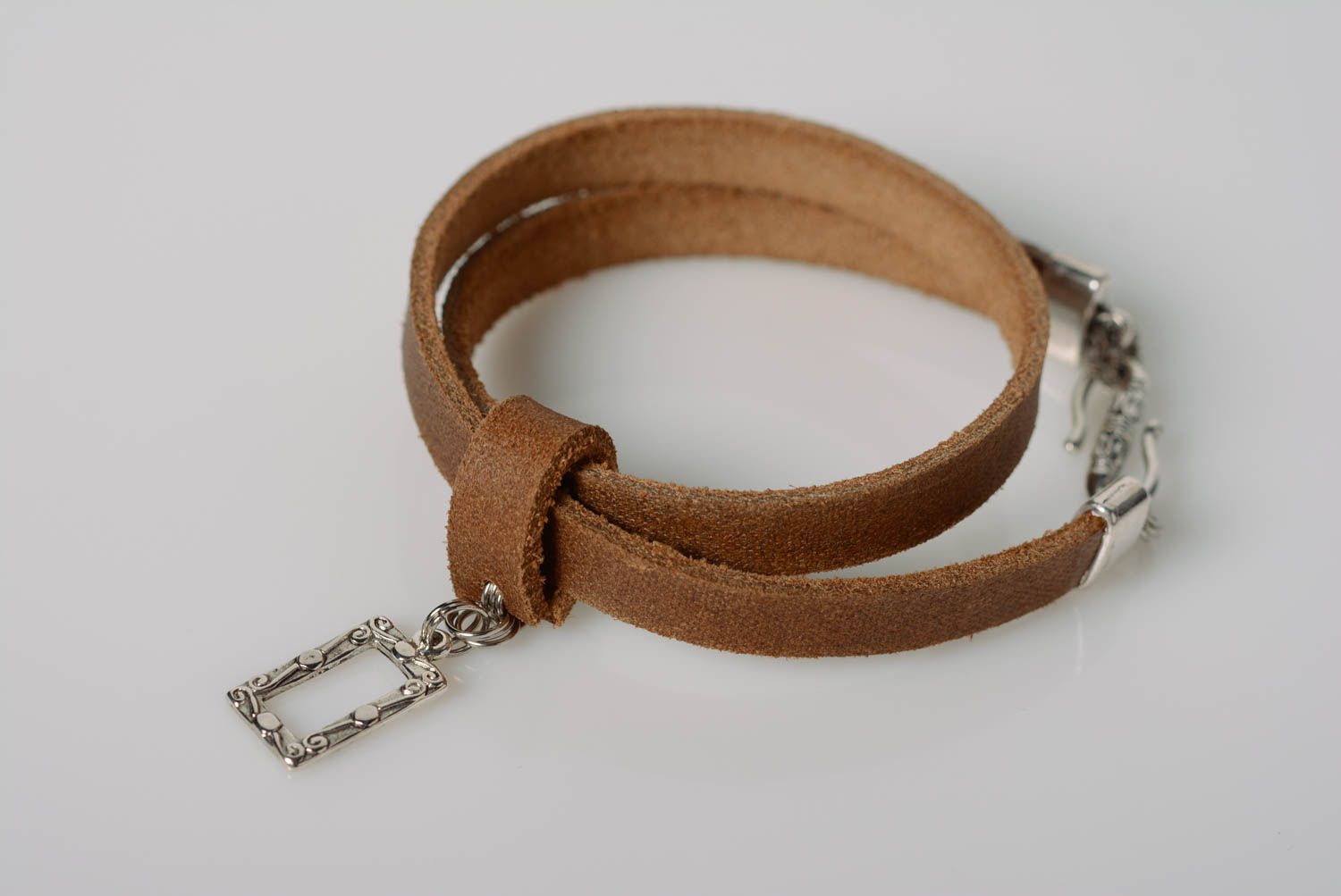 Bracelet fait main réalisé de cuir naturel marron avec pendeloque métallique photo 1