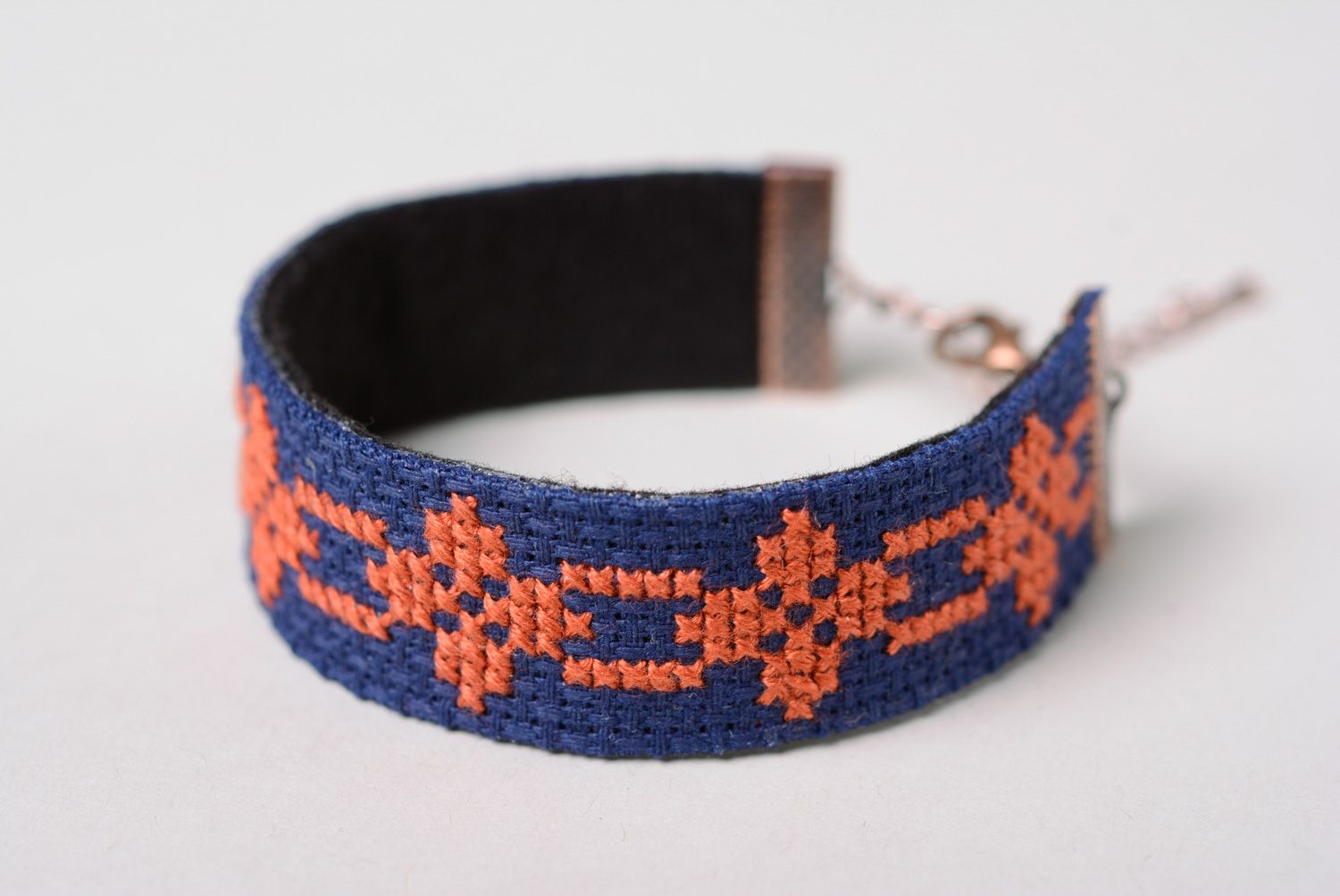 Handmade women's wrist bracelet with ethnic embroidery on dark blue background photo 2