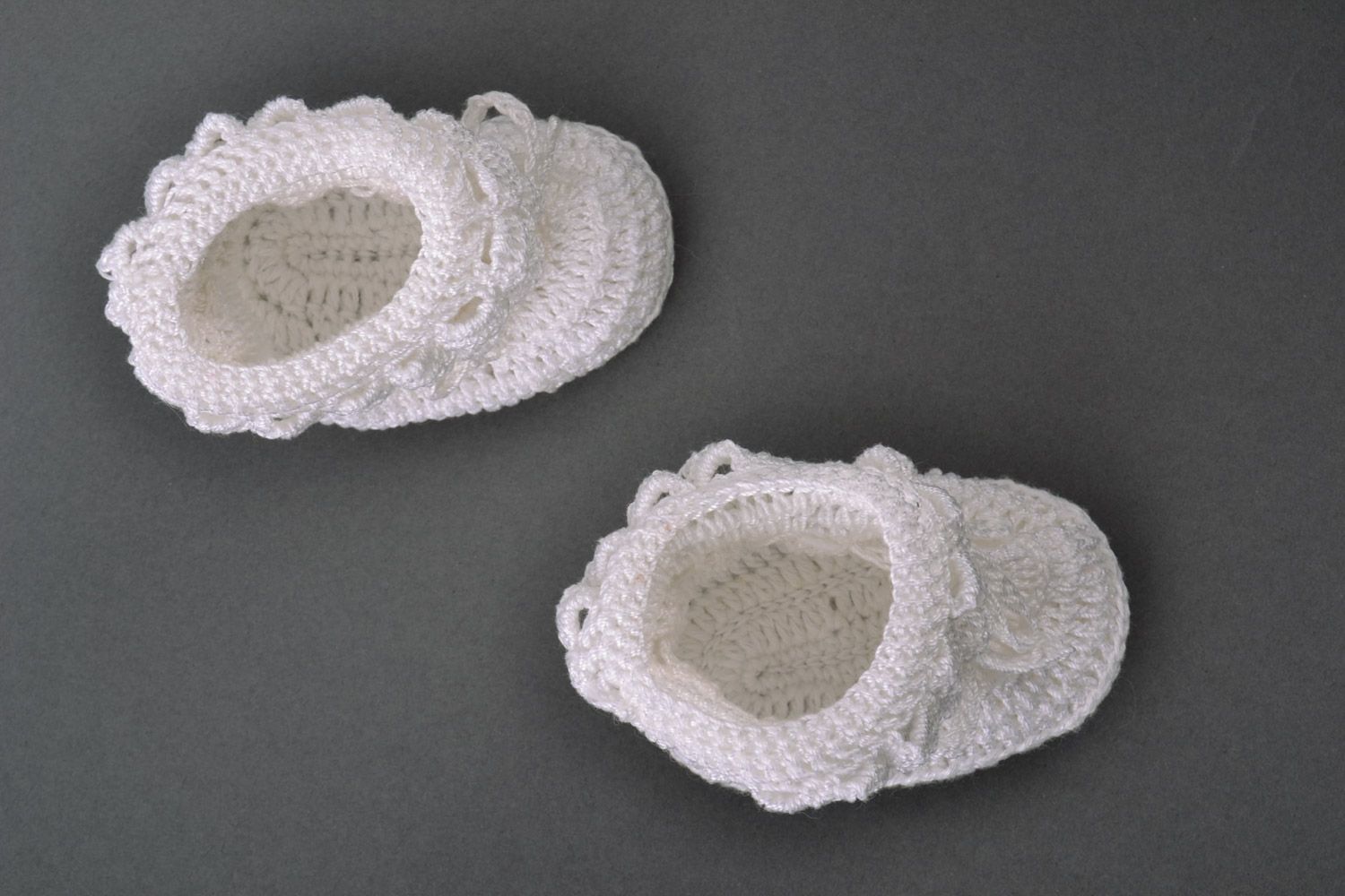 White handmade baby booties knitted of wool and cotton in the shape of shoes photo 2