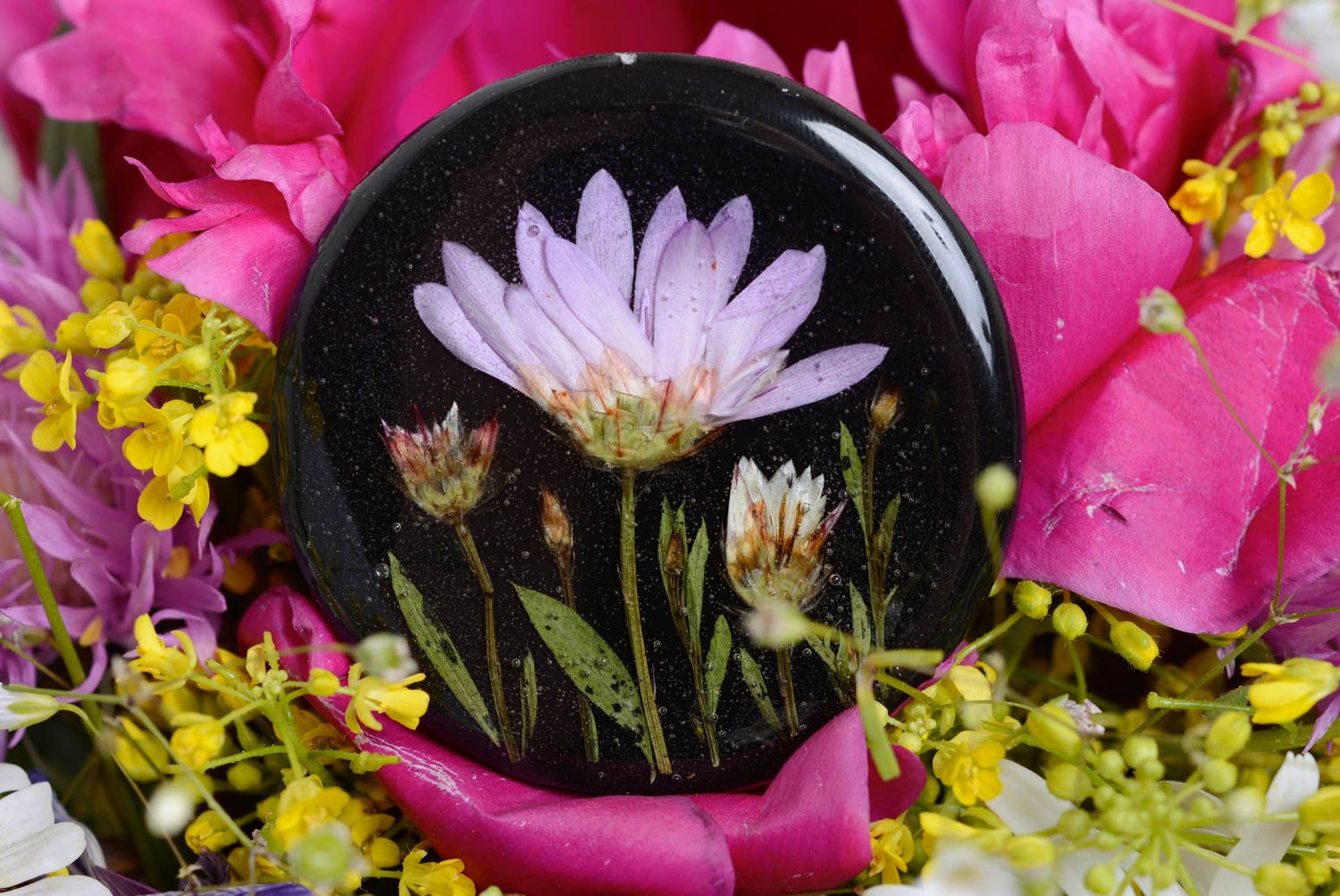 Künstlerische handgemachte Brosche mit Blumen in Epoxidharz rund dunkel handmade foto 1