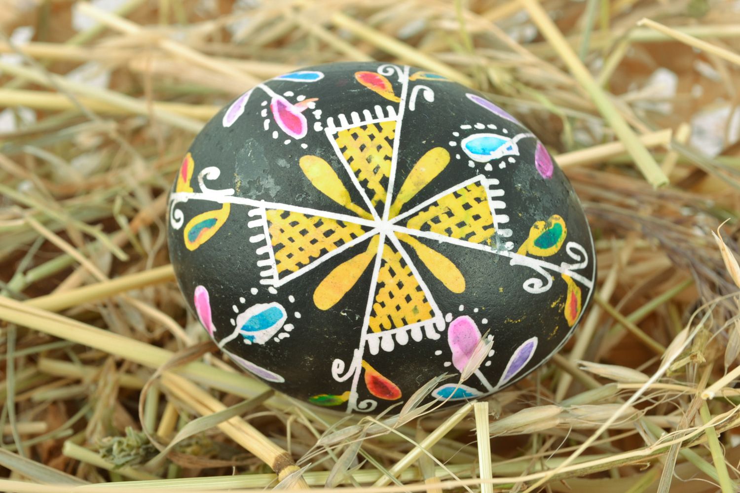 Handmade Easter egg with floral ornament on black background painted with wax photo 1