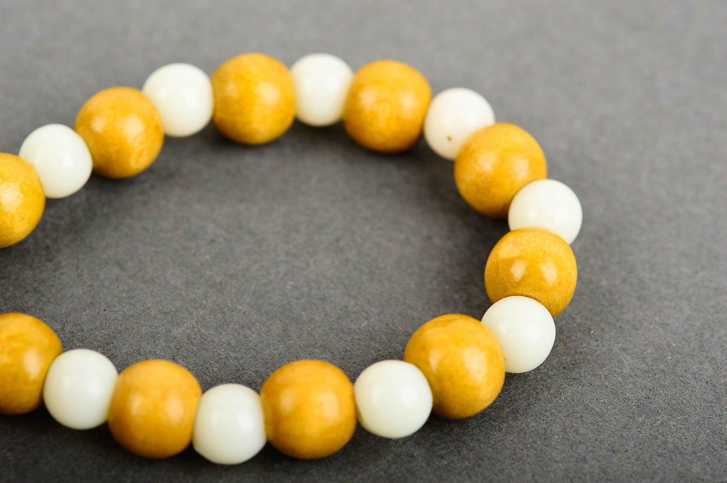Stretchy beaded bracelet made of yellow wooden and white plastic beads photo 5