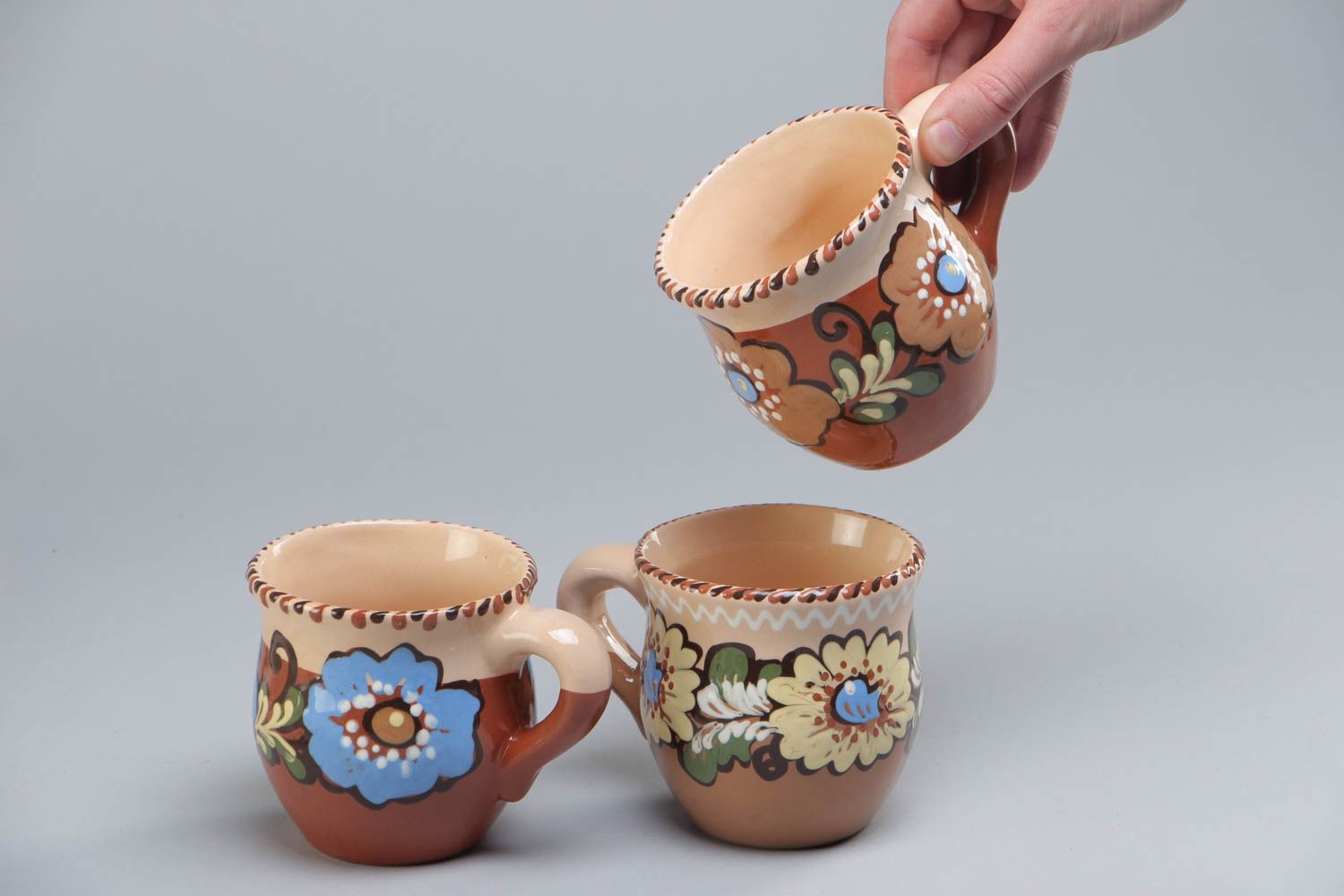 Set of three glazed village-style tea cups with painted flower pattern photo 5
