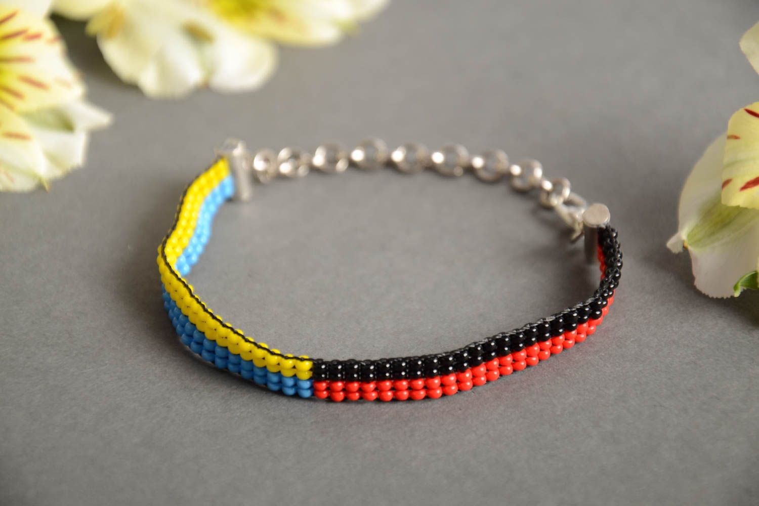 Bracelet fin en perles de rocaille bleu jaune noir rouge sur chaîne fait main photo 1