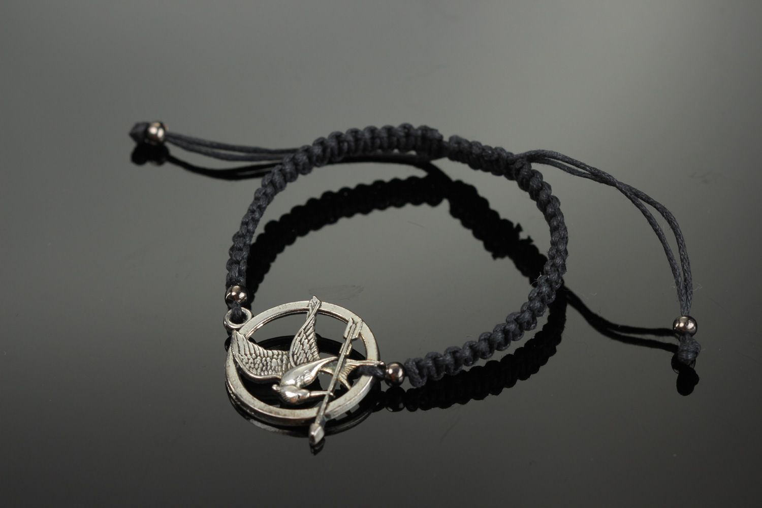 Handmade black friendship wrist bracelet woven of cord with metal charm Mokingjay photo 1