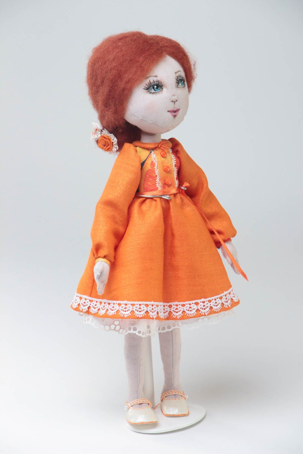 Handmade designer fabric soft doll in orange dress with thin lace on stand photo 2