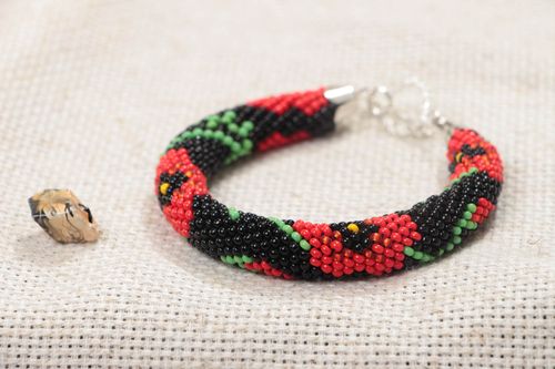 Handmade beaded cord bracelet with red floral pattern on black background - MADEheart.com