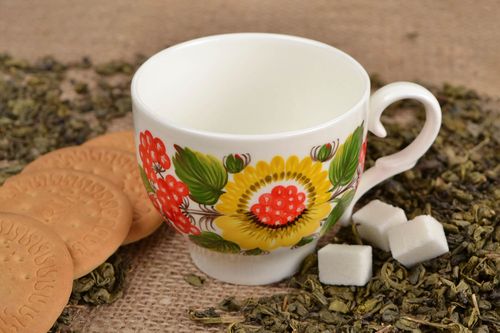 White porcelain handmade teacup with bright Russian-style floral pattern in green, red, and yellow color - MADEheart.com